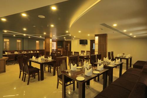 a restaurant with tables and chairs in a room at D Fort Hotel Kollam in Kollam