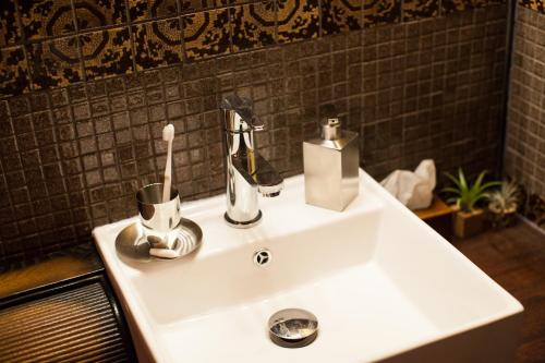 a bathroom sink with a toothbrush and a toothbrush holder at Bamba Hotel Tokyo-Private Townhouse- in Tokyo