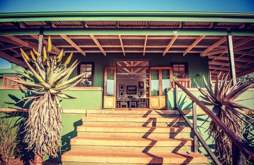 a house with a staircase leading to the front door at Three Tree Hill Lodge in Bergville