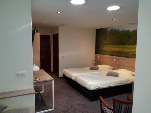 two beds in a room with a painting on the wall at Hotel Het Landhuis in Oldenzaal
