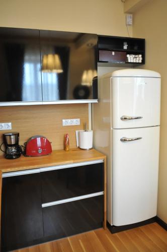 a kitchen with a white refrigerator and a counter at Luxury Apartment in Braşov