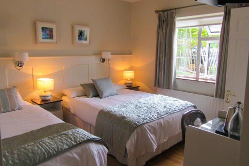 a hotel room with two beds and a window at Doonshean View Bed and Breakfast in Dingle