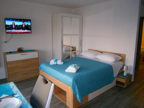 a bedroom with a bed and a tv on the wall at Studio apartment Luzia in Komiža