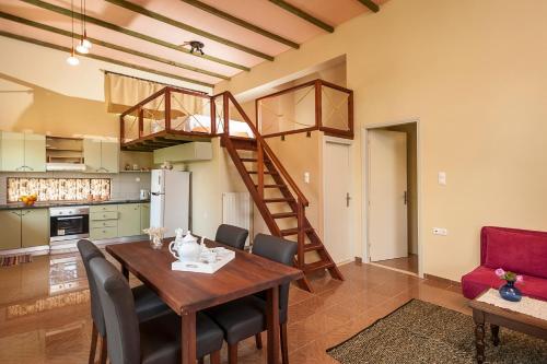 une cuisine et une salle à manger avec une table en bois et un escalier dans l'établissement Filio House, à Stalós