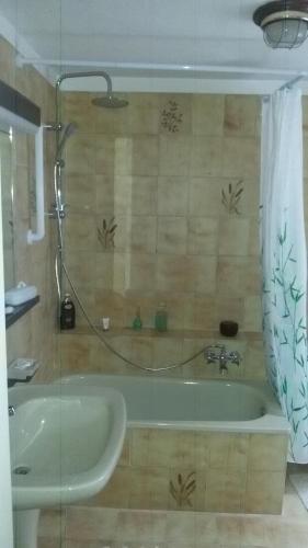 ein Badezimmer mit einer Badewanne und einem Waschbecken in der Unterkunft B&B IL TERRAZZO in Pollone