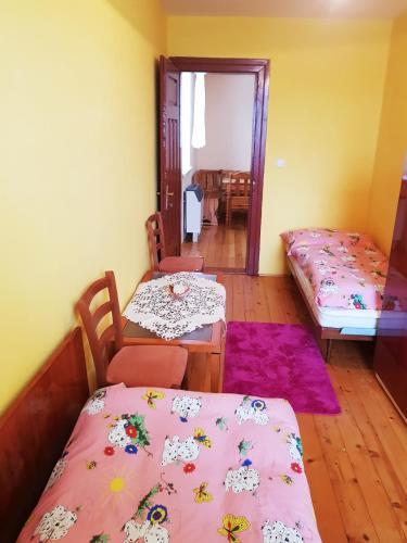 a room with two beds and a table and chairs at Privat DAŇO in Lisková