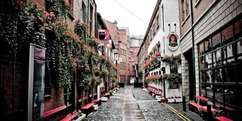 una calle estrecha con flores a los lados de los edificios en Rooftop Apartments, en Belfast