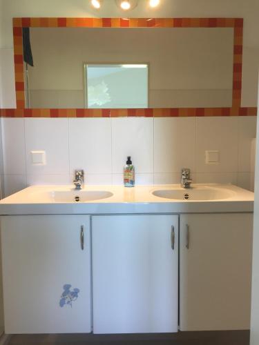 a bathroom with two sinks and a mirror at Lekerweg 32 in Wijdenes