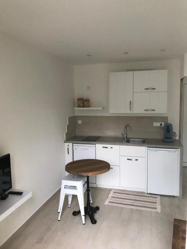 une cuisine avec des armoires blanches et une table en bois dans l'établissement Avignon Campagne, à Avignon