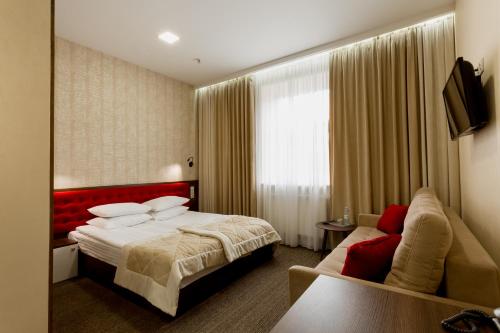 a hotel room with a bed and a couch at Hotel Natalia 18 in Lviv