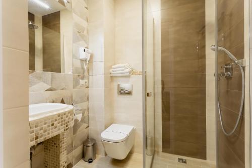 a bathroom with a toilet and a glass shower at Hotel Natalia 18 in Lviv
