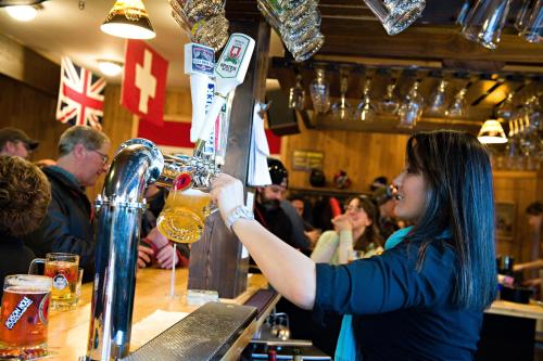 a woman bartender making a drink at a bar at The Alpenhof in Teton Village