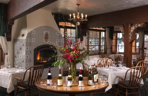 una sala da pranzo con tavolo e bottiglie di vino di The Alpenhof a Teton Village