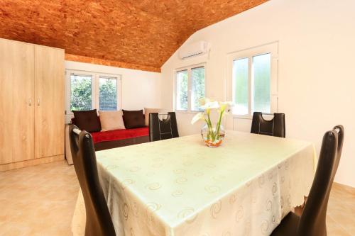 a dining room with a table with a vase of flowers on it at Apartment Sea Star in Tivat