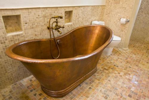 a copper tub in a bathroom with a toilet at Guayaba Inn Boutique Hotel in San Cristóbal de Las Casas
