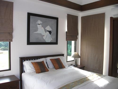 1 dormitorio con 1 cama con sábanas blancas y ventanas en Leelawadee Garden Resort, en Ao Nam Mao