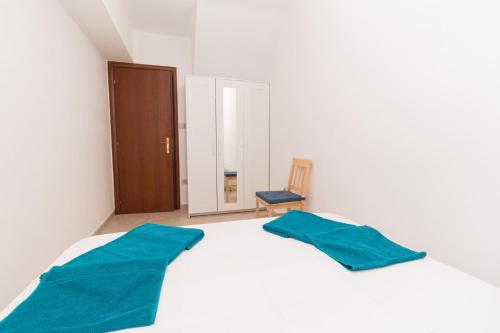a white bed with two blue pillows on top of it at Alexger Psakoudia Seaview House in Psakoudia