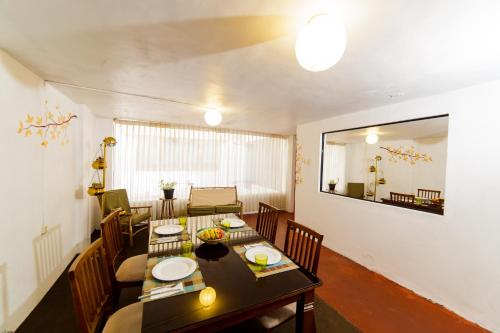 a dining room with a table and a mirror at Apartment & Rooms Cusco in Cusco