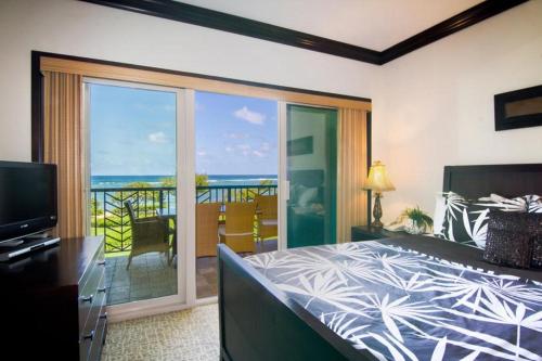 um quarto com uma cama e vista para o oceano em Waipouli Beach Resort G-306 em Kapaa
