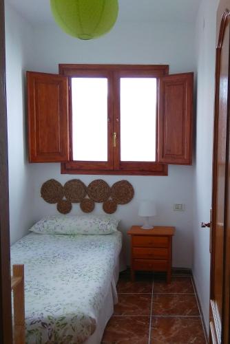 a small bedroom with a bed and a window at El Passeig in Vilafames