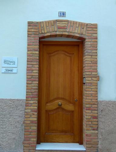 a wooden door in a brick archway in a building at El Passeig in Vilafames