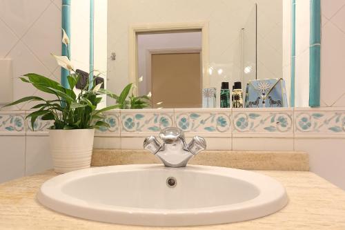 a bathroom sink with a faucet and a mirror at Riccardo Condotti Suite in Rome