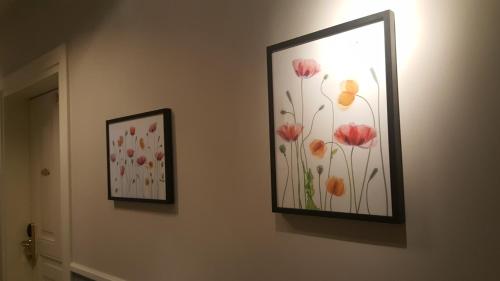 two pictures of flowers are hanging on a wall at Boutique Hotel Kugel Wien in Vienna
