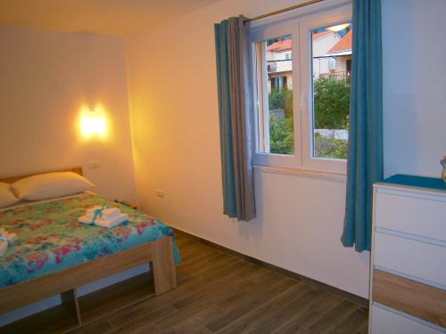 um pequeno quarto com uma cama e uma janela em Room Vilma em Komiža