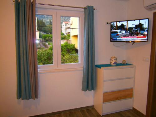 a room with a window and a tv on a wall at Room Vilma in Komiža