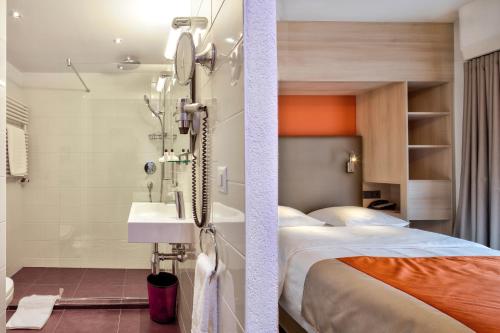 a hotel room with a bed and a sink at Hotel Eden in Geneva