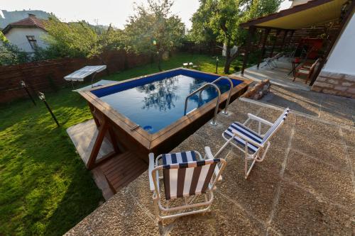 una piscina con 2 sillas y una mesa en Villa Rose, en Belogradchik