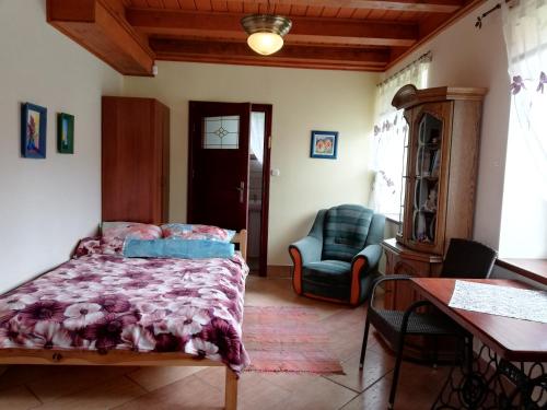 a bedroom with a bed and a chair and a table at Agroturystyka Giże in Giże