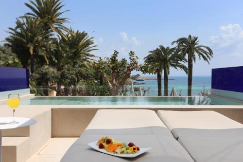 a table with a plate of food and a glass of wine at Hotel Son Caliu Spa Oasis in Palmanova