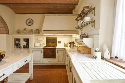 a kitchen with white cabinets and white counter tops at Casalta Di Pesa in Siena
