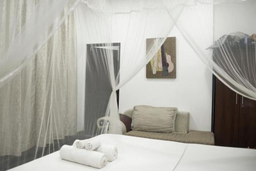 een slaapkamer met een bed en een stoel met handdoeken bij Butterfly Jewel in Unawatuna