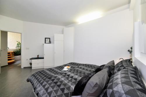1 dormitorio con 1 cama con sábanas negras y grises en Apartment with fireplace and terrace en Zagreb