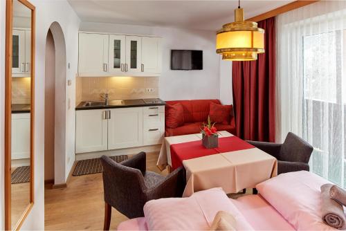 ein Wohnzimmer mit einem Tisch und einem roten Sofa in der Unterkunft Apartments Neue Post in Filzmoos
