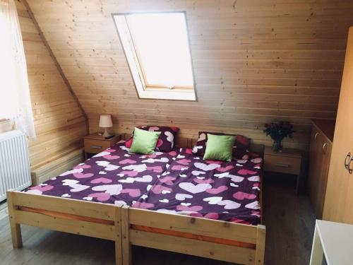 ein Schlafzimmer mit einem Bett in einer Holzhütte in der Unterkunft Siedlisko na Zaciszu domek in Kąty Rybackie