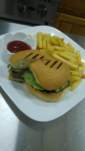 a sandwich and french fries on a plate with ketchup at Hotel Alexandrina in Kingstown