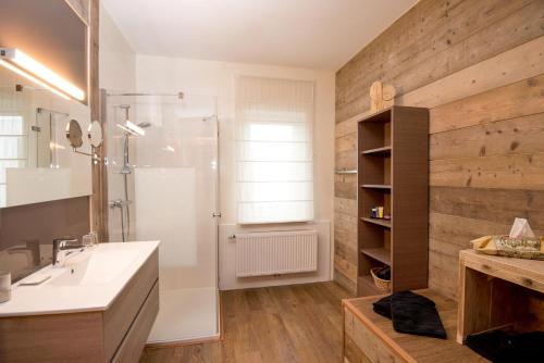 uma casa de banho com um chuveiro e um lavatório branco em B&B Het Groote Genoegen em Manderfeld