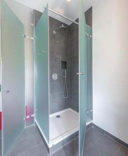 a shower with a glass door in a bathroom at Hotel Kloster Holzen in Allmannshofen