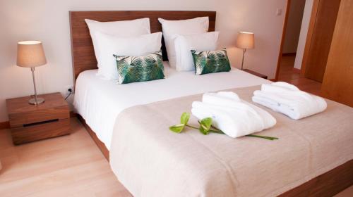 a hotel room with a bed with towels on it at Ana's Apartments in Sines