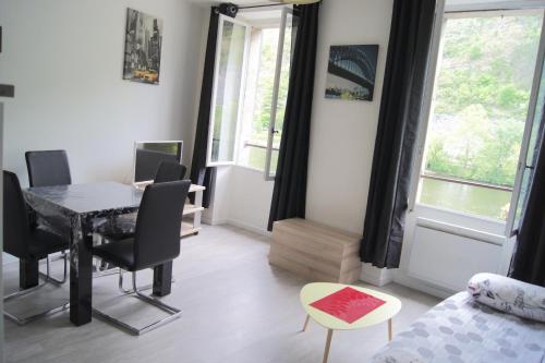 - un salon avec un bureau et une table avec des chaises dans l'établissement Joly, à Cahors