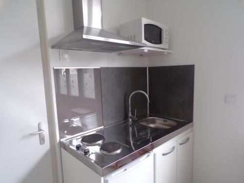 une petite cuisine avec un évier et un micro-ondes dans l'établissement studio Turquoise, à Berck-sur-Mer