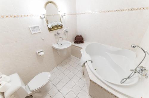 a white bathroom with a toilet and a sink at Pension Marie in Český Krumlov