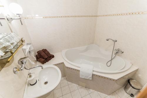 a white bathroom with a tub and a sink at Pension Marie in Český Krumlov