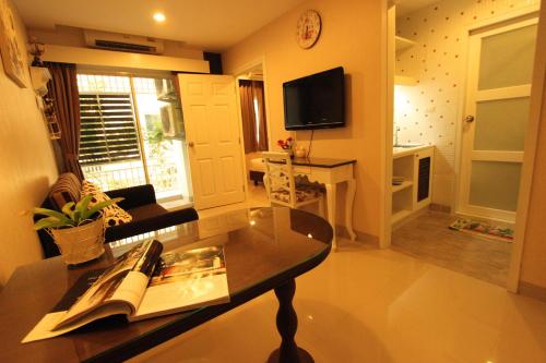 a living room with a couch and a table with a book at At Residence Suvarnabhumi Hotel in Lat Krabang
