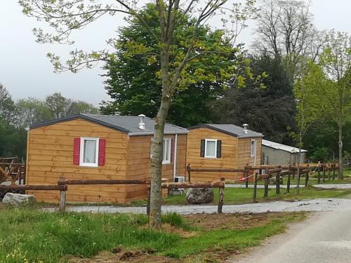a log cabin with a fence and a tree at Les chalets de Bes "Le Campagnard " in Lacombe