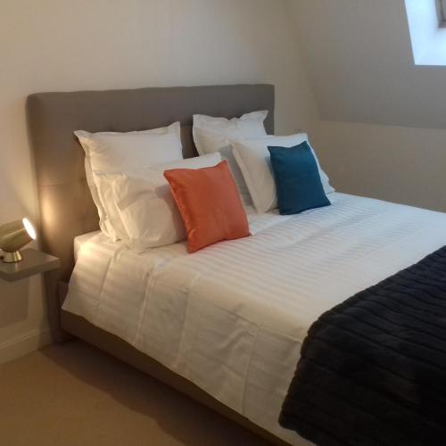 un lit avec quatre oreillers dessus dans l'établissement Balcon avec vue panoramique de la mer, le village et la campagne - parking privé, à Wimereux