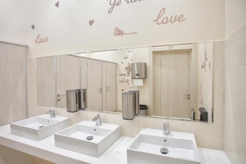 łazienka z 2 umywalkami i dużym lustrem w obiekcie Bishotel w mieście Lipieck